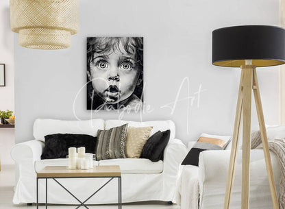 Black-and-white canvas portrait of a child with wide eyes and open mouth mounted on a white wall titled baby bright eyes