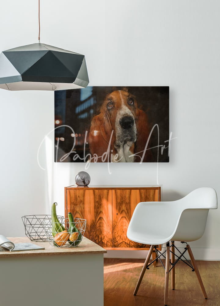 A framed canvas print of a close-up brown and white basset hound portrait displayed indoors