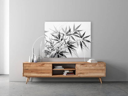 Black and white bamboo minimalist canvas print with leaf design mounted above wooden media console