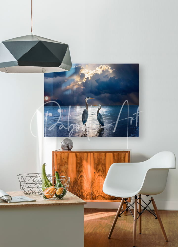 A rectangular canvas print titled blue herons at dawn featuring two herons standing in water under a dramatic sky