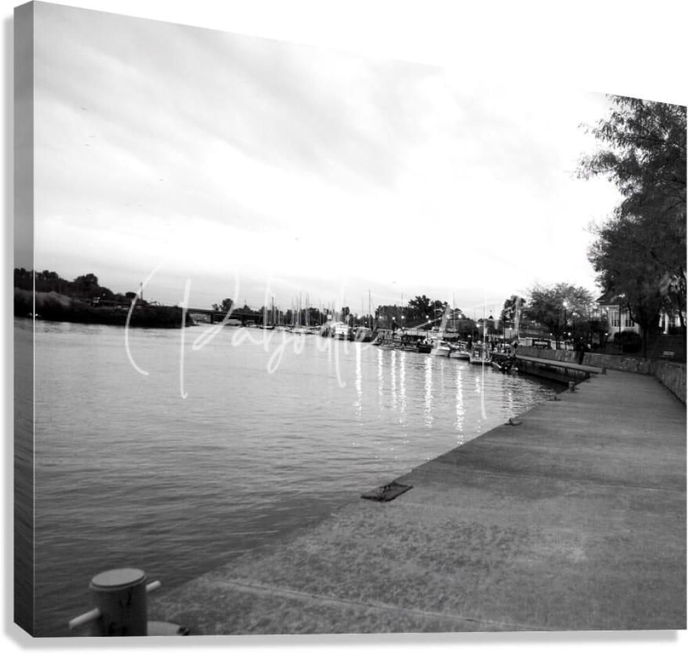 Black and white canvas print of cloudy dawn featuring a waterfront marina with boats docked along a concrete pier