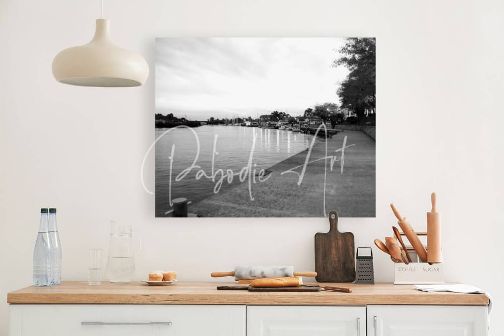 Black-and-white photographic print titled cloudy dawn featuring a waterfront scene with cursive text pabodie art