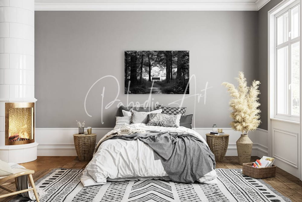 A cozy bedroom with dark to light bedding in white and gray featuring woven side tables and decorative pillows