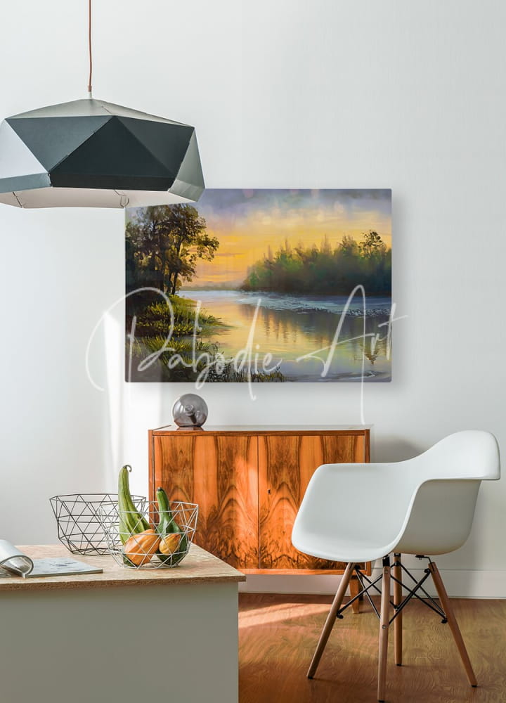 A serene sunset landscape painting titled As The Dawn Breaks with warm orange and yellow hues in a black metal frame