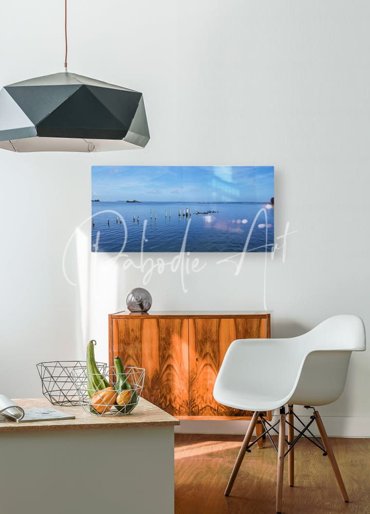 A sleek black geometric pendant light with a faceted design hangs from the ceiling by Dock Of Better Days