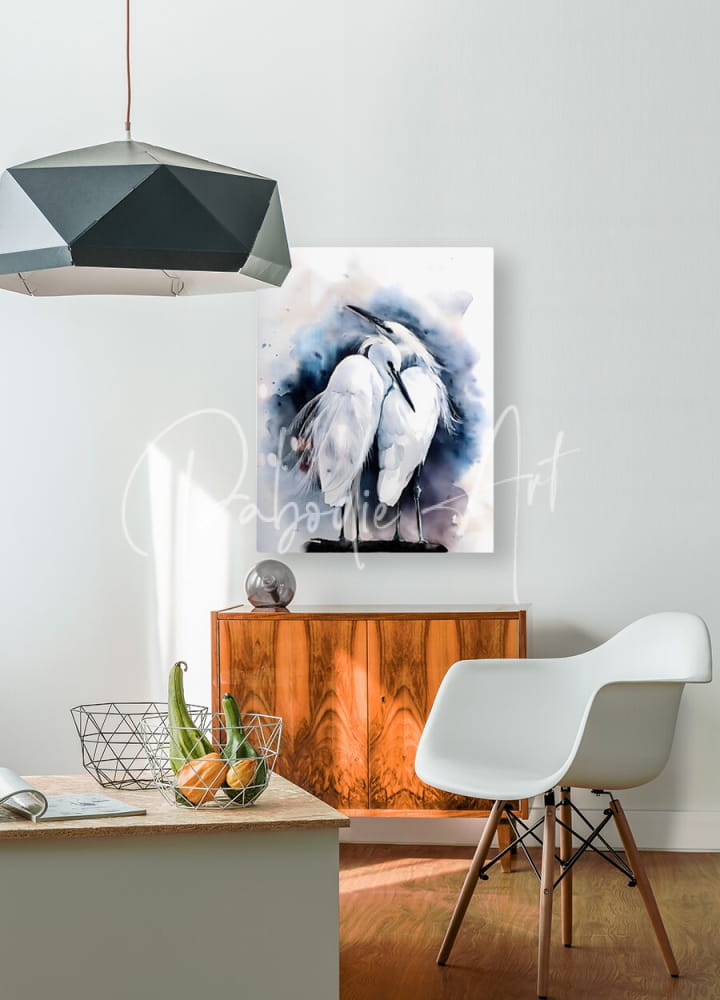 A watercolor painting titled Egret Love Inkwash featuring two white herons in soft blue and gray wash displayed on a wall