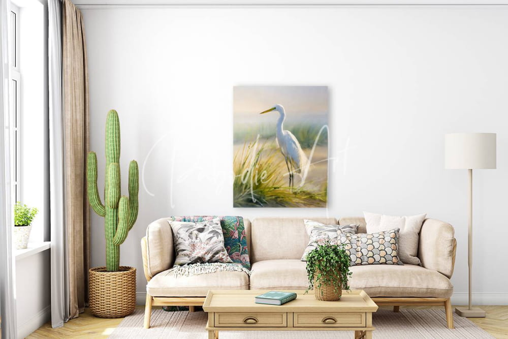 Egret by the sea is a serene white egret painting with soft brushstrokes hanging above a beige sofa in a minimalist room