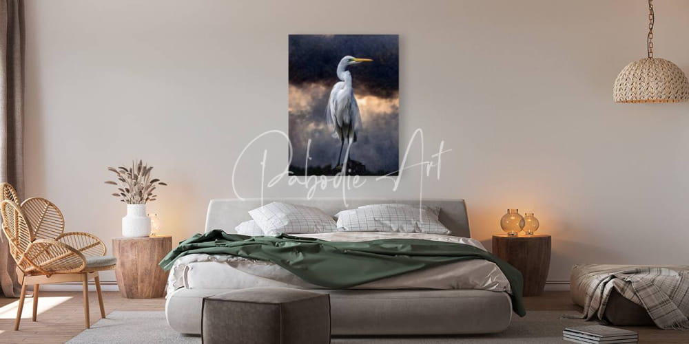 A striking canvas print titled Egret standing tall featuring a white egret against a moody sky with orange and gray clouds