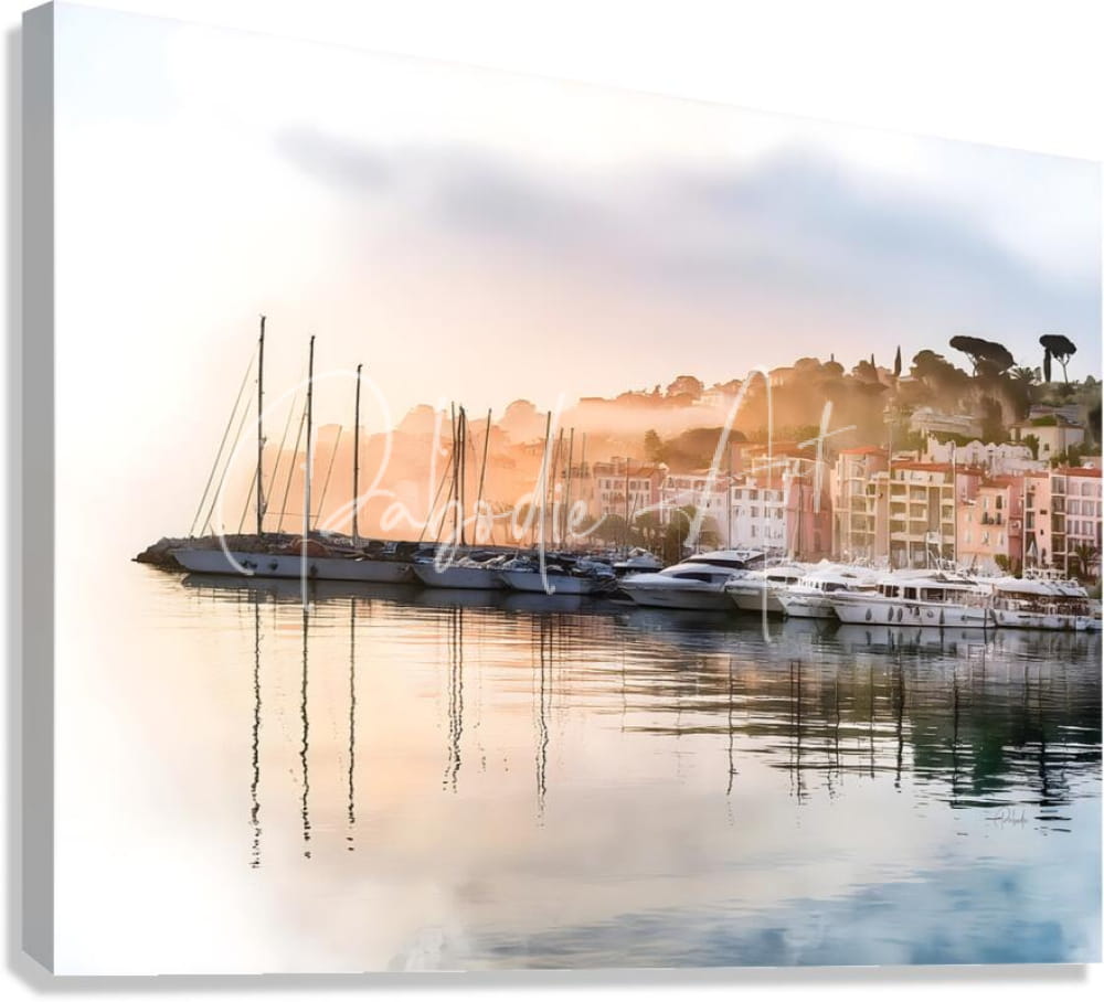 A serene canvas print of the french riviera shoreline reflecting orange and pink sunrise over sailboats and buildings