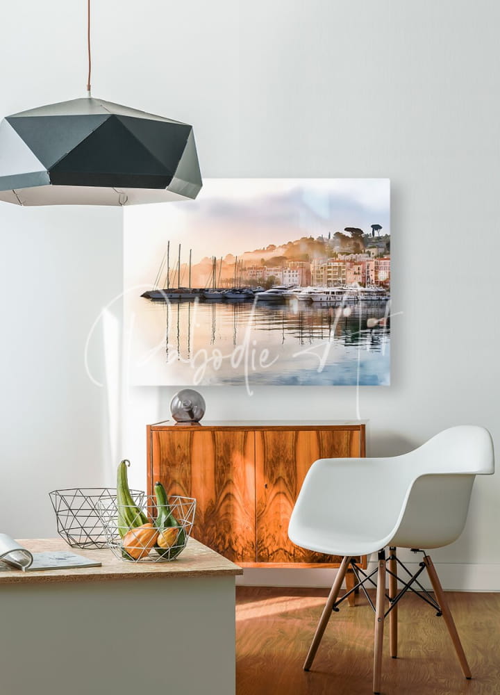 A modern black geometric pendant light with faceted angular design hanging from the ceiling in french riviera shoreline reflections