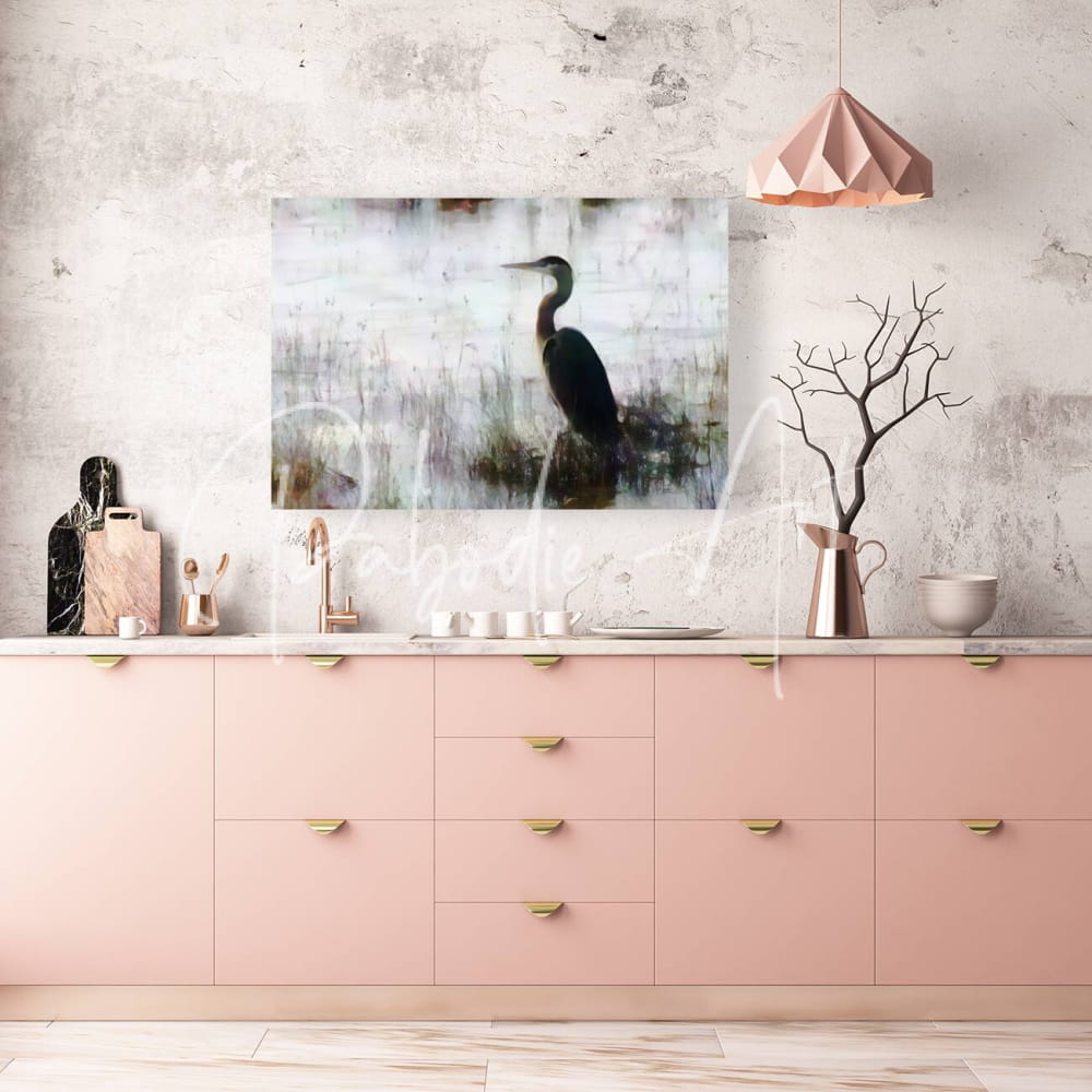 A rectangular canvas print of a dark great blue heron standing in misty water mounted on a textured wall