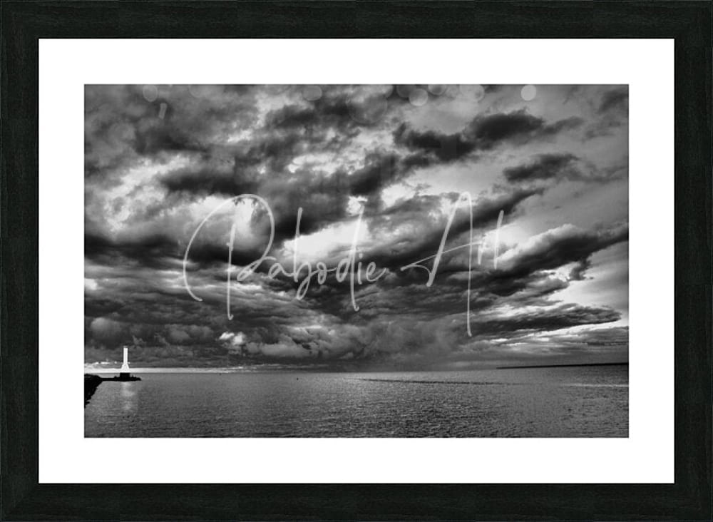 Black-framed black and white photographic print of huron lighthouse under dramatic incoming storm clouds