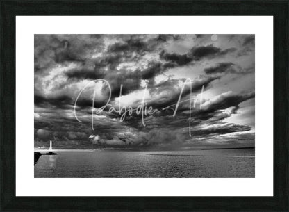 Black-framed black and white photographic print of huron lighthouse under dramatic incoming storm clouds