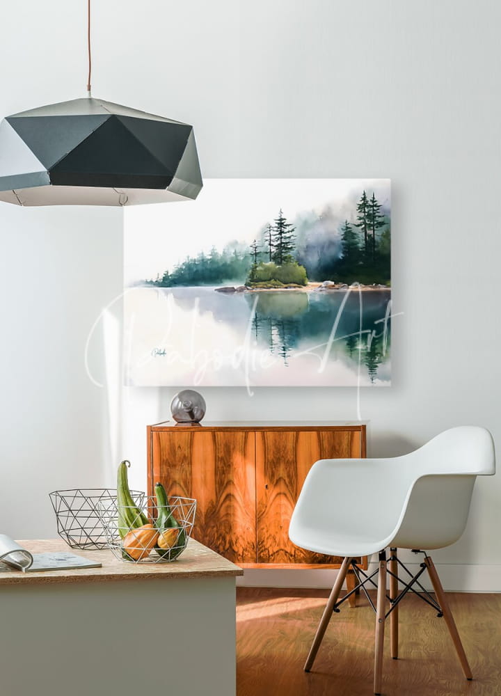 The quiet place watercolor painting of a misty forested island reflected in calm water displayed above a wooden cabinet