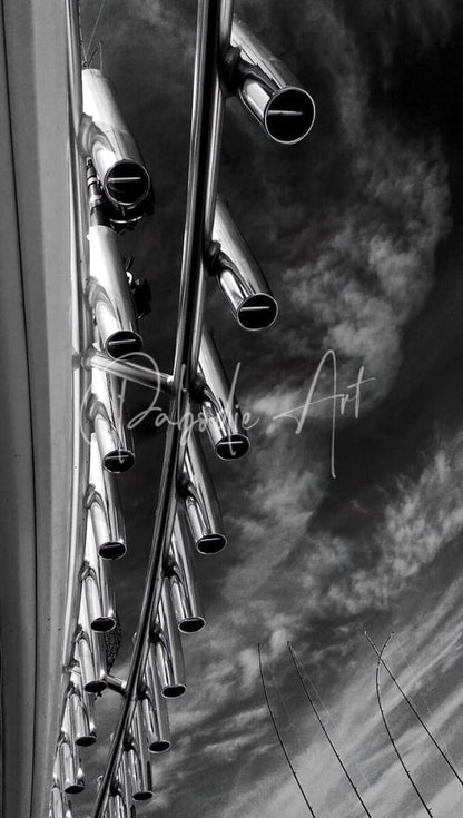 Shiny metallic silver rod holders made of durable metal tubes arranged vertically against a cloudy sky background