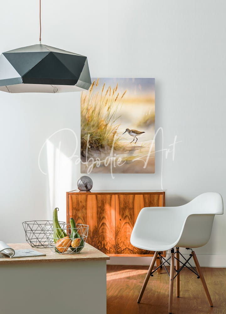 A serene watercolor painting titled the sandpiper shoreline featuring a sandpiper bird in golden grass under a warm sky