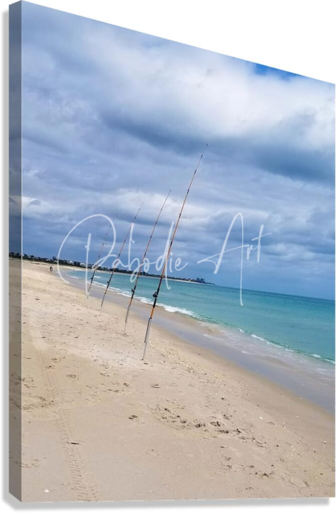 Beige canvas print shorefishing with fishing rods in sand on a beach under a cloudy sky