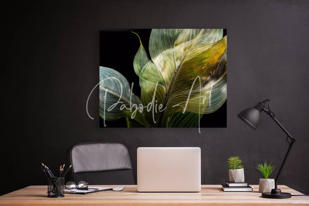 A framed canvas print titled tropical leaves on black featuring vibrant green and yellow leaves on a black background