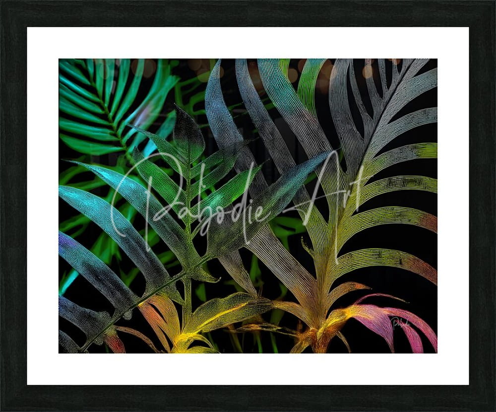 A framed art print titled tropical leaves at night featuring stylized tropical fern leaves in iridescent teal green yellow and pink